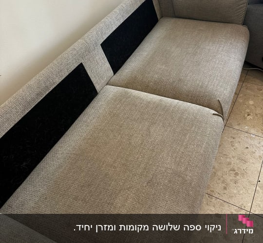 ספה אפורה עם כריות על רצפת שיש